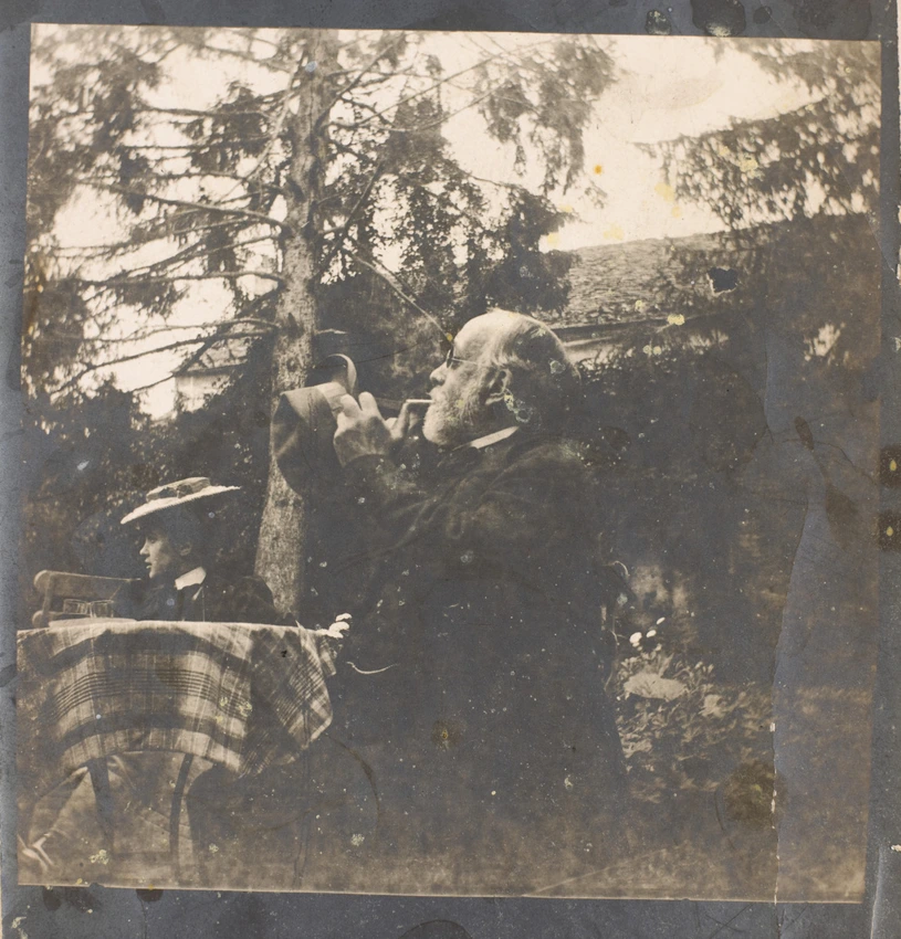 Degas assis à table dans un jardin avec une jeune femme au chapeau - Albert Bartholomé