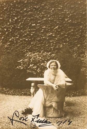 Harry C. Ellis - Loïe Fuller assise dans un jardin, sur un siège en pierre à l'a...