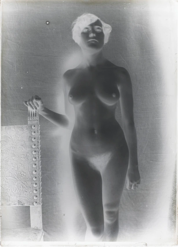 Femme nue debout de face, vue jusqu'aux mollets, main droite posée sur une chaise - François-Rupert Carabin
