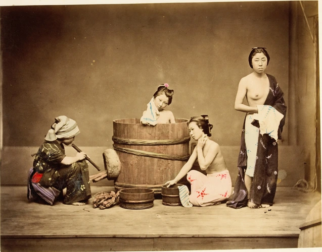 Felice Beato - Japonaises prenant leur bain. Une domestique souffle pour activer...
