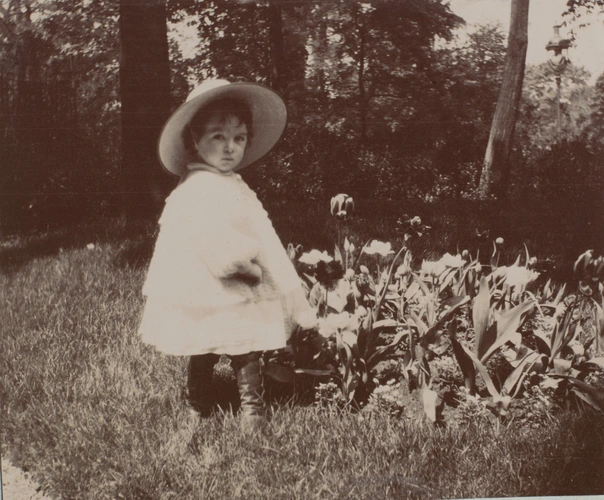 Anonyme - Enfant debout dans un jardin