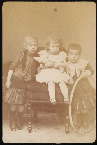Ad. Braun & Cie - Un bébé assis sur des coussins et deux enfants debout à ses cô...