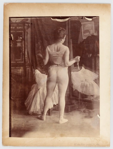 Anonyme - Lili Grenier en danseuse ajustant une ceinture, dans l'atelier d'Alber...