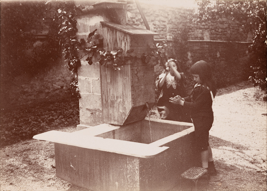 Une fontaine dont coule de l’eau occupe le premier plan de l’épreuve