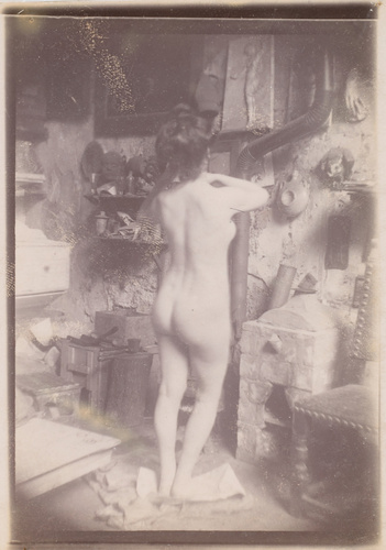 Femme nue debout de dos, dans l'atelier