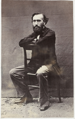 Achille Bonnuit - Homme barbu assis à califourchon sur une chaise