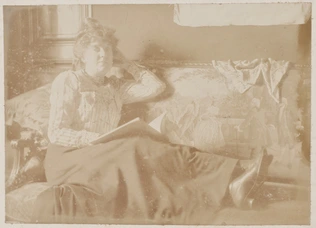 Anonyme - Jeune femme lisant, assise sur un sofa, les jambes allongées