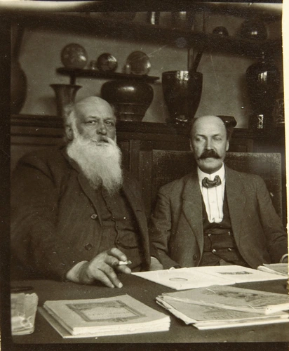 Anonyme - Auguste Delaherche avec un homme moustachu consultant des documents pa...