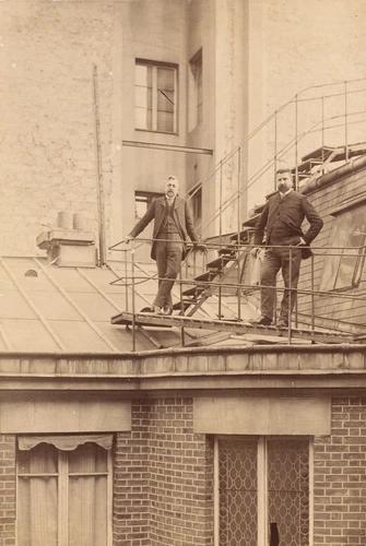 Gustave Eiffel - G. Eiffel et un homme barbu, debout au pied d'un escalier métal...