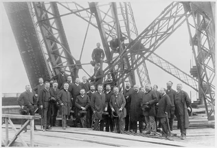 Groupe d'hommes debout sur la première plate-forme de la Tour leur chapeau à la main. G. EIffel est au centre le 16 Juin 88 - Louis-Emile Durandelle