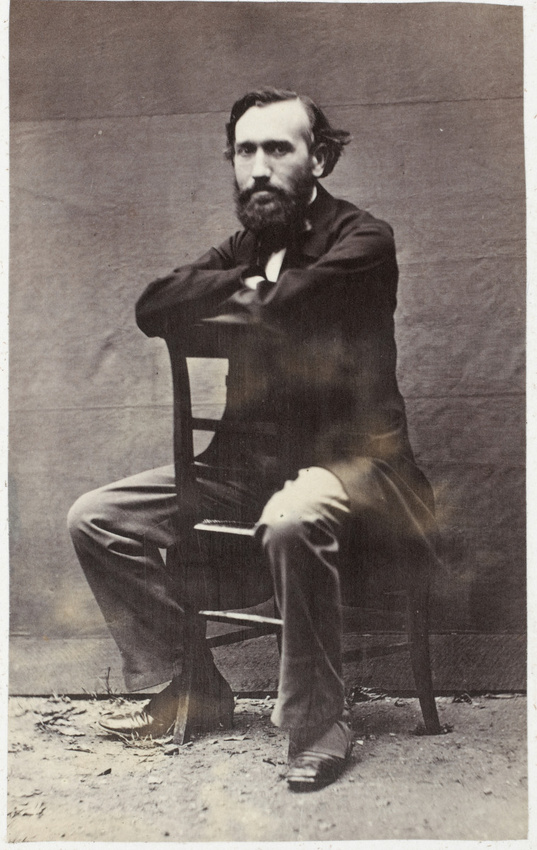 Achille Bonnuit - Homme barbu assis à califourchon sur une chaise