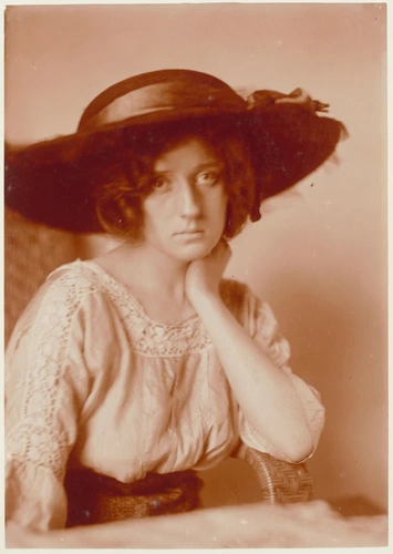 Portrait à mi-corps d'une jeune femme chapeautée d'une capeline et accoudée à un fauteuil en osier - Charles Augustin Lhermitte