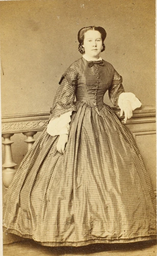 Reutlinger - Femme debout, en pied, le coude gauche posé sur une balustrade