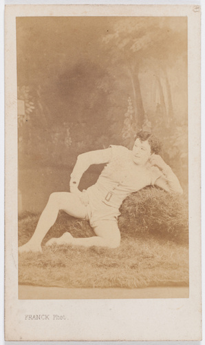 Franck - Paul Legrand en costume de scène, assis la main droite posée sur la cui...