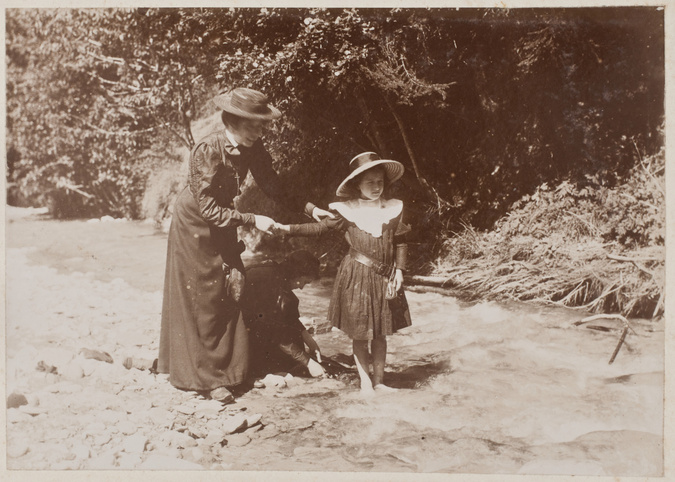 Anonyme - Femme et fillette debout, une jeune fille accroupie entre elles, en ex...
