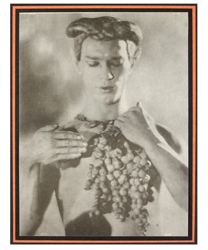 Nijinsky à mi-corps, tenant une grappe de raisins - Adolphe Meyer