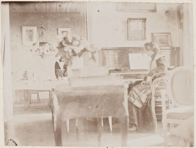 Anonyme - Yvonne Rouart dans un intérieur, rue Duquesne, assise près d'un piano