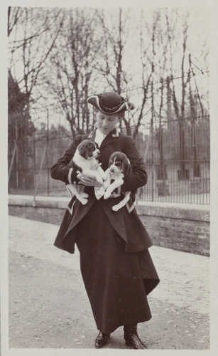 Anonyme - Simone Menier en tenue de chasse portant deux chiots