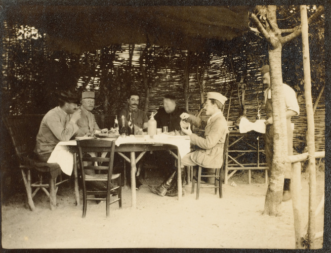 Anonyme - Cinq militaires à table sous un abri en bois