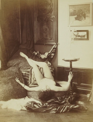 Anonyme - Femme nue couchée sur le dos, pieds posés en hauteur sur une chaise