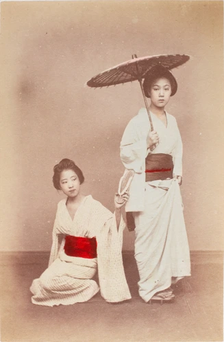 Ueno Hikoma - Deux jeunes japonaises dont une à genoux, l'autre debout tenant un...