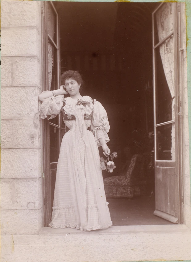 Claire Salles debout dans une porte-fenêtre de la Villa Salles à Beaulieu - Anonyme
