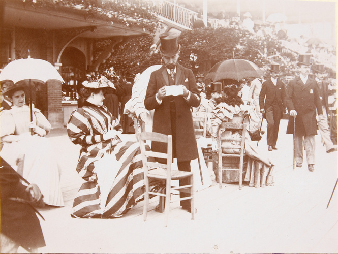 Henri Lemoine - Homme debout lisant, femmes assises au champs de courses