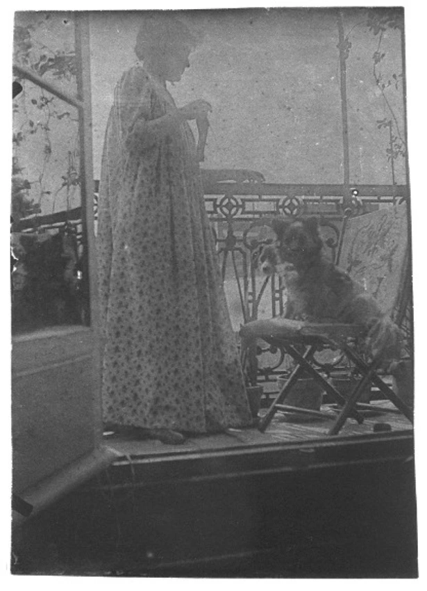 Madame Rivière debout sur un balcon en compagnie d'un chien (photographie prise de intérieur de l'appartement) - Henri Rivière