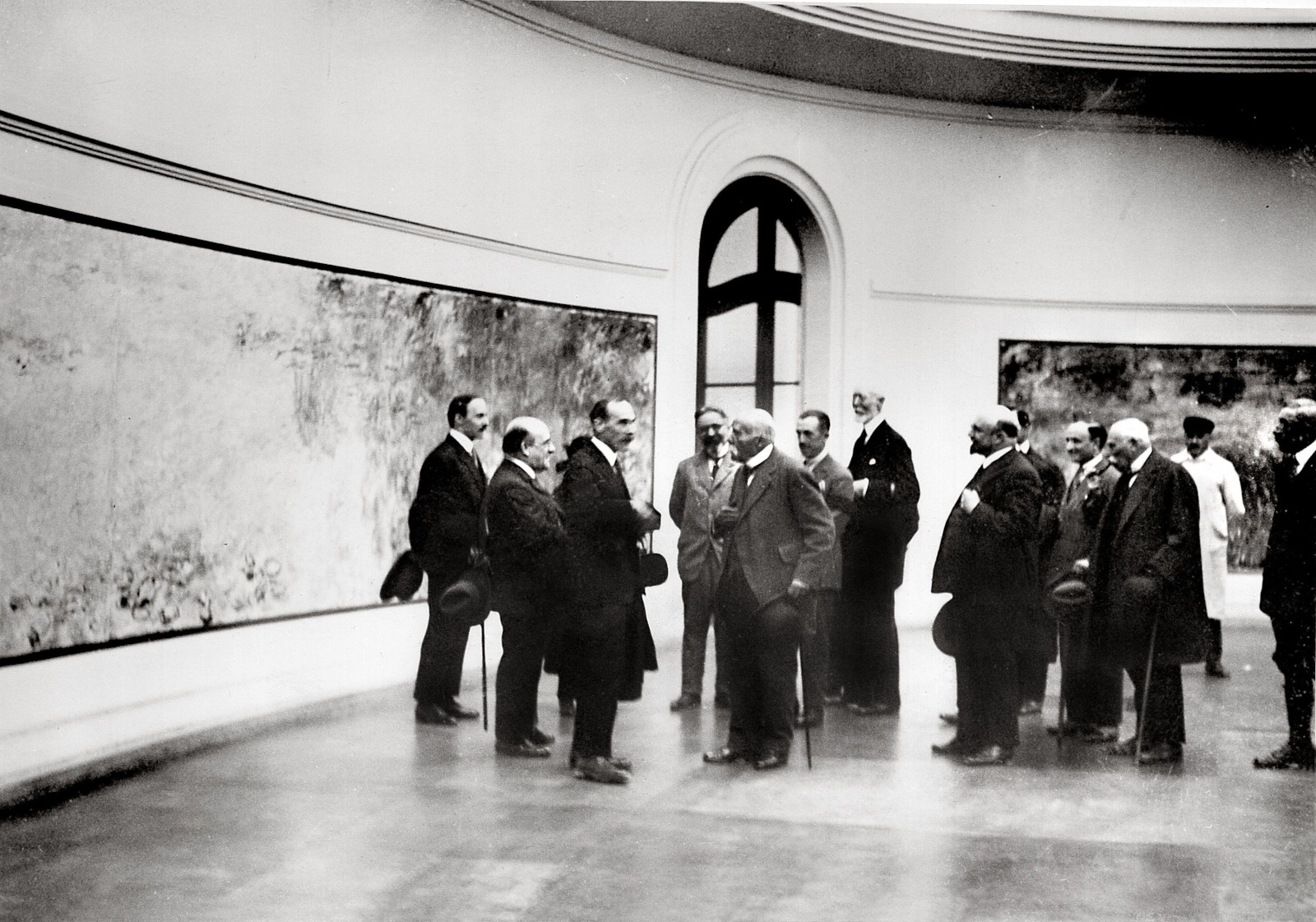 Photographie historique de visiteurs dans une salle ovale des Nymphéas au musée de l’Orangerie